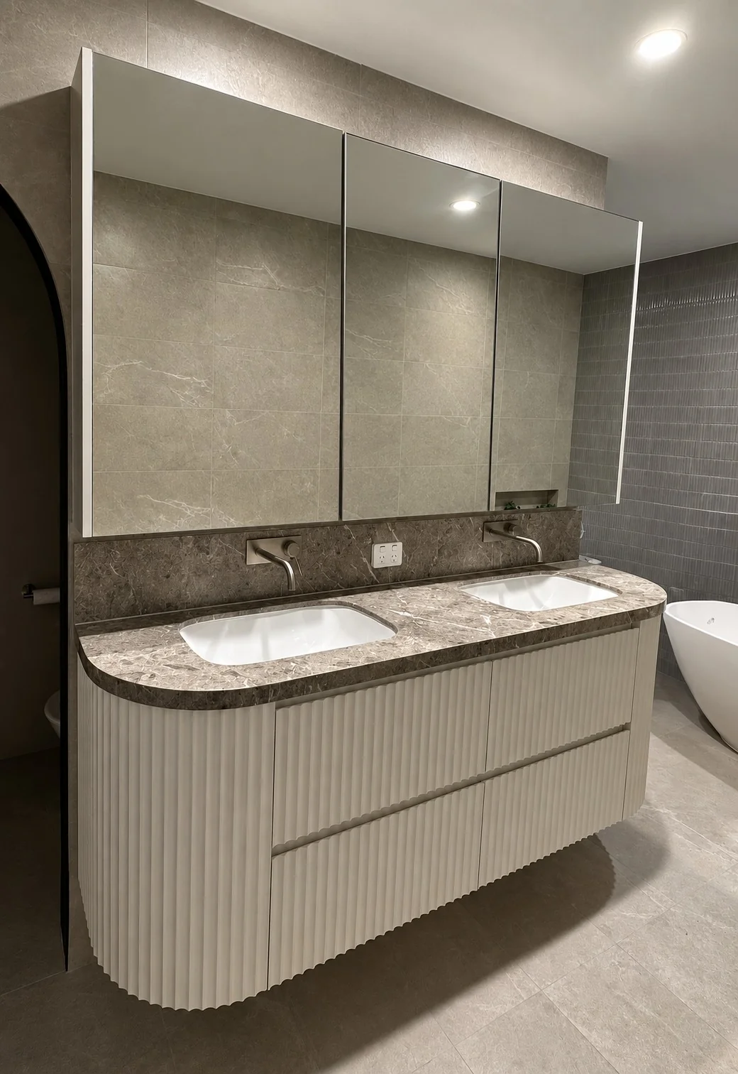 Fluted double vanity with mirrored storage
