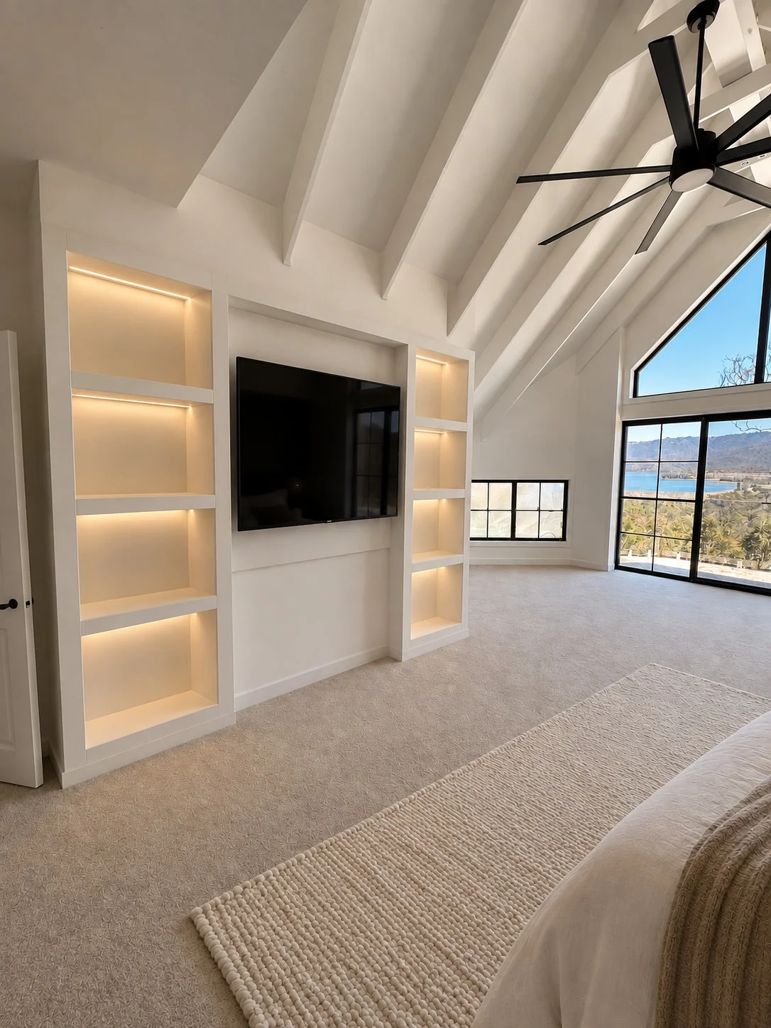 Built-in bedroom TV cabinetry with illuminated display shelving