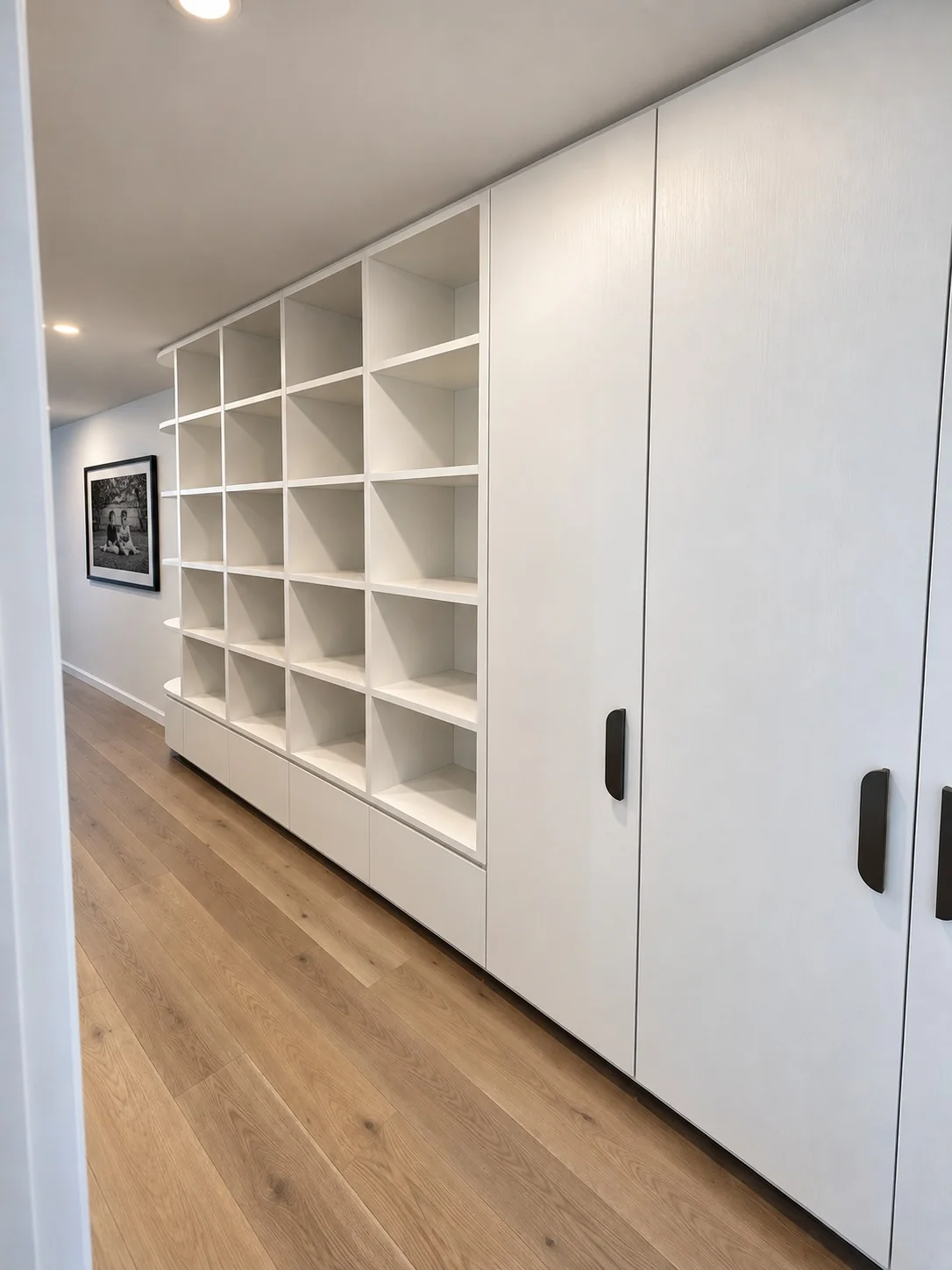 White built-in storage cabinetry with open shelving and sliding doors