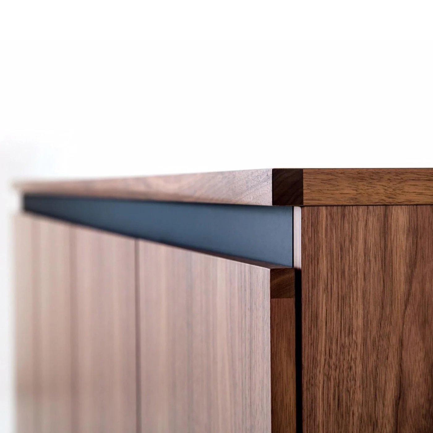 Brass mirror and drawer hardware detail in walnut joinery